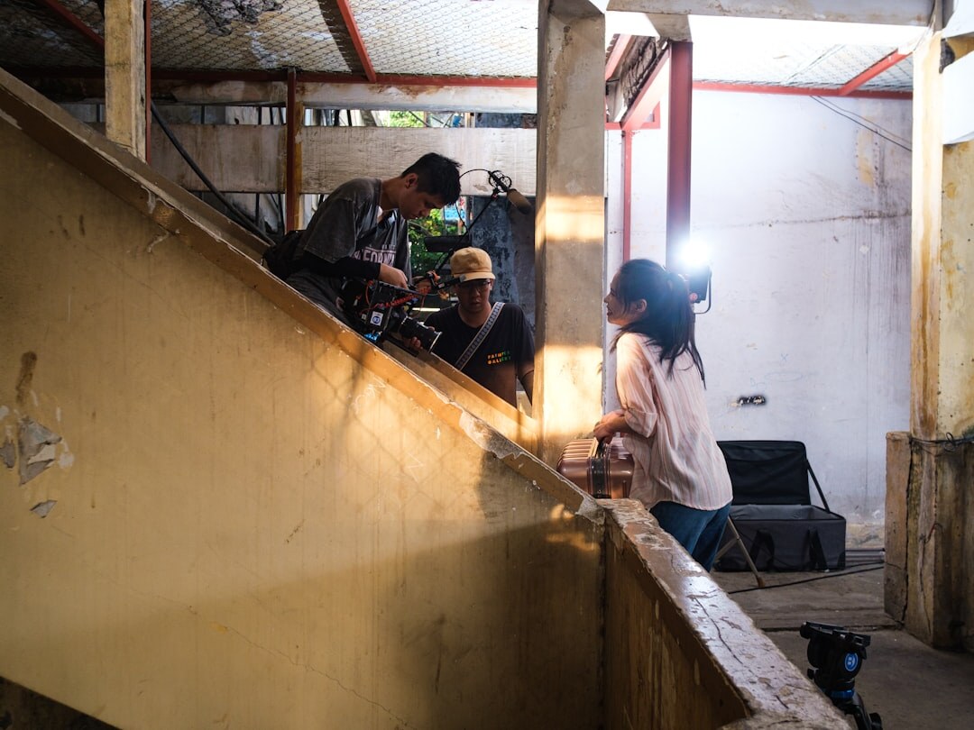 Film crew setting up a camera and lights on a small production set